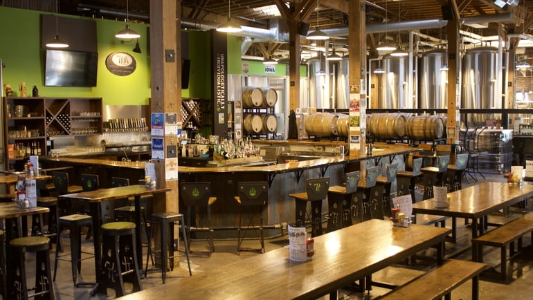 A wide-angle shot of the bar at 7 Hills Brewery, including a view of the beer tanks in the background.