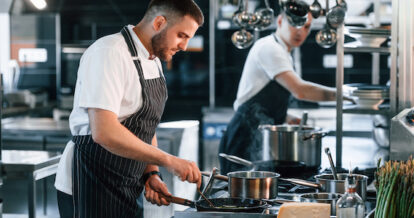 Kitchen staff working alongside one another in a shared commercial kitchen space.