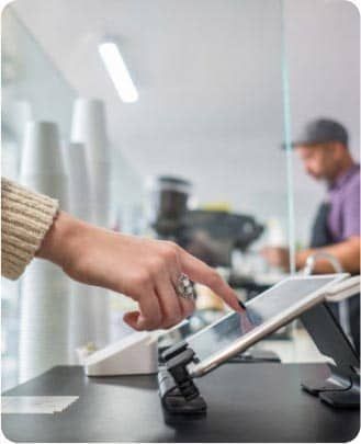 Restaurant worker touching a tablet to use the restaurant management system