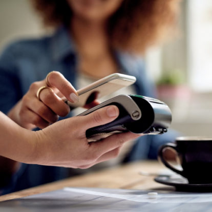 A customer tapping their phone to use as payment on a payment terminal.