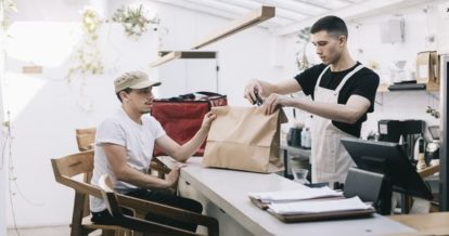 Man picking up online ordering order at restaurant counter