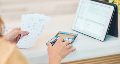 Woman in a restaurant calculating profit margin.