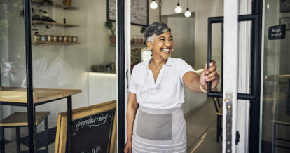 Woman opens front door of restaurant.