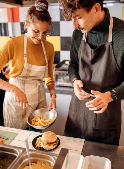 photo of two restaurant employees assembling a food order